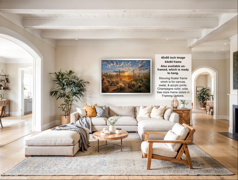 The image is a large framed picture hanging on a wall in a spacious living room. The room has a modern and elegant design, with a large sectional sofa, a coffee table, and various decorative elements such as potted plants and vases.
