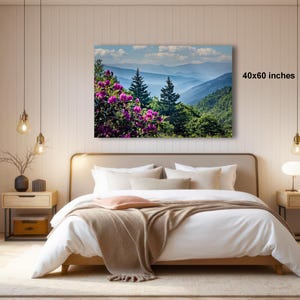 a serene bedroom with a large bed, wooden furniture, and a painting of a mountain landscape hanging on the wall.