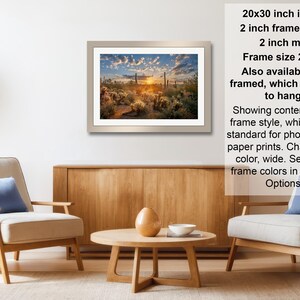 The image is a living room with a framed landscape painting hanging on the wall, a wooden coffee table in the center, and two chairs facing each other.