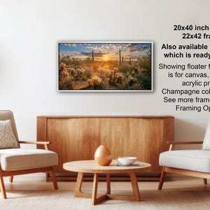 a living room with a wooden coffee table, two white armchairs, and a potted plant. Above the coffee table, there is a framed landscape painting hanging on the wall.