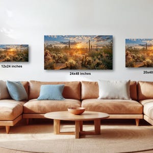 a living room with a large sectional sofa, a coffee table, and three framed landscape paintings hanging on the wall above the sofa.