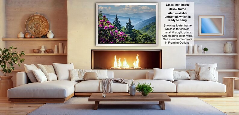 a cozy living room with a fireplace, white sofas, and a coffee table. The room has a warm and inviting atmosphere, with a fireplace providing a focal point and a painting of a mountain landscape hanging above it.