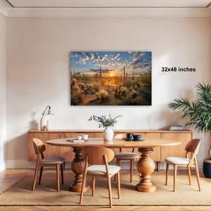 a modern dining room with a large wooden table surrounded by matching chairs. A large framed landscape painting depicting a desert scene with a sunset is hanging on the wall above the table. The painting is 32x48 inches in size.