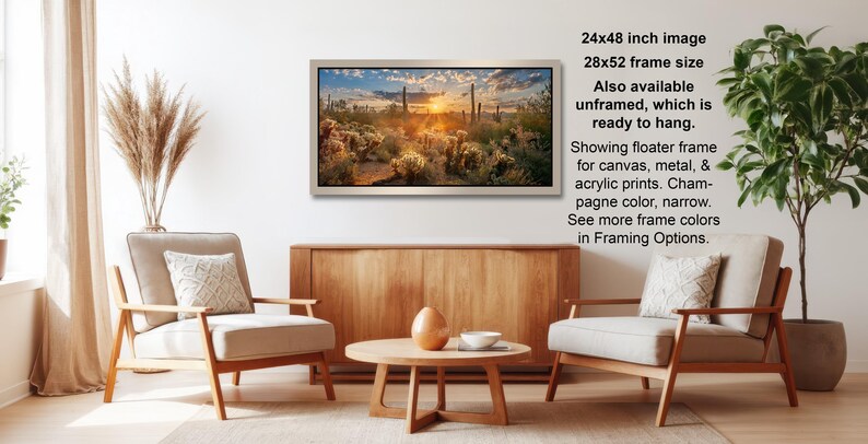 a living room with a wooden coffee table, two white armchairs, and a framed landscape painting hanging on the wall.