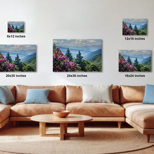 a cozy living room with a large sectional sofa, a coffee table, and several potted plants. The walls are adorned with three framed landscape photographs, each varying in size and depicting different mountainous scenes. The photographs are arranged in a grid-like pattern, with the largest one at the top and the smallest at the bottom. The room has a warm and inviting atmosphere, with the furniture and decor complementing the natural beauty of the landscape images.