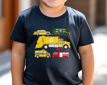 May include: A young boy wearing sunglasses and a navy blue t-shirt with a graphic of five different vehicles, including a yellow taxi, a green refuse truck, a yellow refuse truck, a yellow taxi, and a red fire engine.
