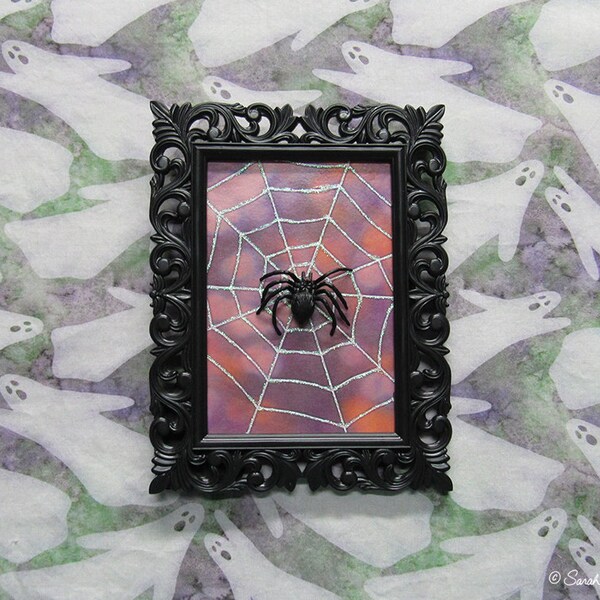 framed spider on spiderweb assemblage - orange purple bokeh - by Sarah Knight, glitter black plastic halloween decor wall art scary but cute