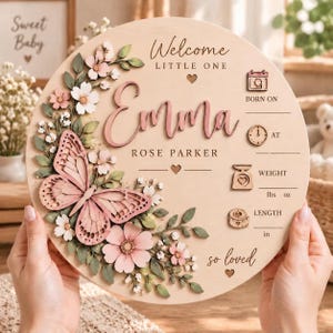 May include: A round wooden birth announcement sign featuring a 3D pink butterfly and floral accents. The text reads Welcome LITTLE ONE, Emma, ROSE PARKER, and so loved. It includes icons for born on, at, weight in lbs oz, and length in inches.