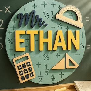 May include: A wooden classroom decoration featuring the name "ETHAN" in yellow block letters, with "Mr." in navy blue script. The design includes mathematical symbols, a protractor, a calculator, and a triangle, all set against a green background.