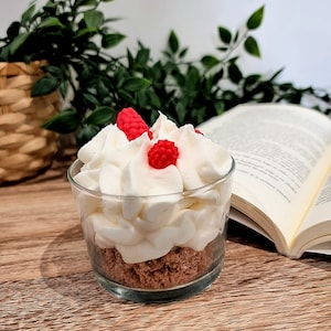 Kerze mit roten Beeren und Sahne