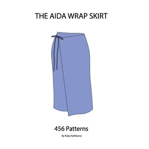 以下が含まれることがあります： ウエストにリボンが付いた青いラップスカート。スカートの名前は「The Aida Wrap Skirt」で、456 Patterns、Ruby Rathboneによるものです。