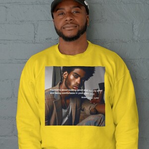 Könnte beinhalten: Gelber Pullover mit einem Schwarzweißbild eines Mannes im Anzug und einem Zitat von Andre Leon Talley, das lautet: "Mode ist, gut auszusehen und sich gut zu fühlen und in seiner Haut wohlzufühlen."
