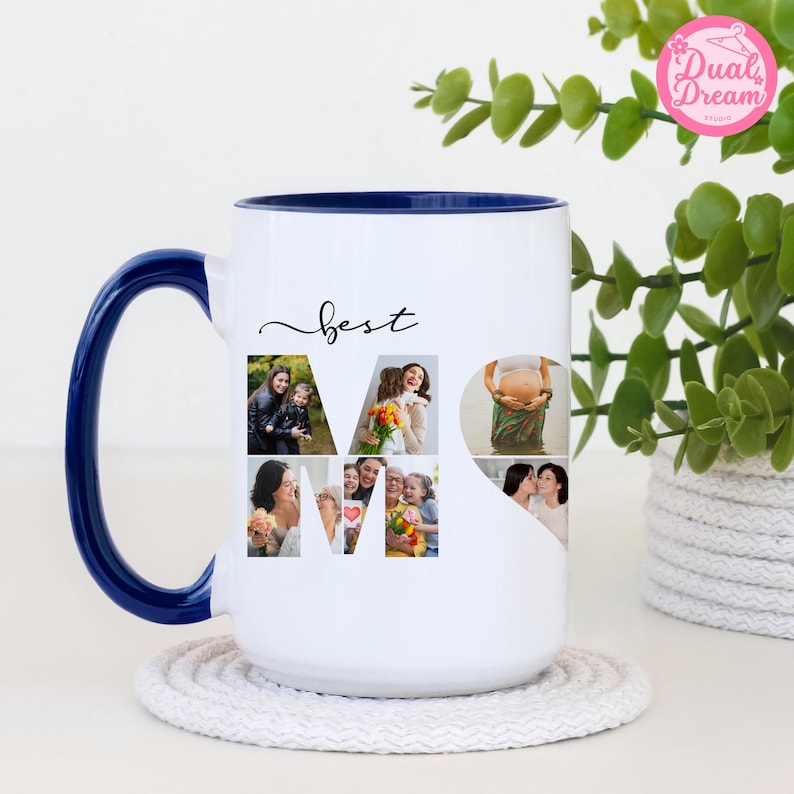 K&ouml;nnte beinhalten: Wei&szlig;er Keramikbecher mit blauem Henkel und Rand, mit dem Wort "best" in Schreibschrift und dem Wort "MOM" aus Familienfotos. Der Becher steht auf einem wei&szlig;en Untersetzer.