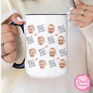 May include: White ceramic mug with a black rim and handle. The mug features a repeating pattern of baby faces and the text "Best Dad Ever" with a small red heart.