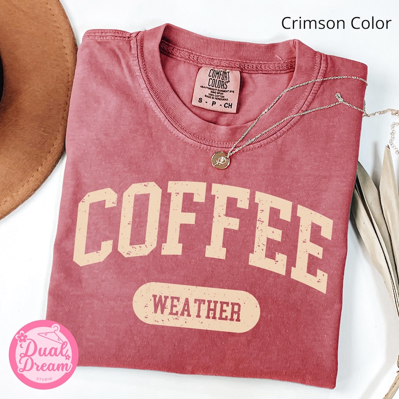 K&ouml;nnte beinhalten: T-Shirt in einem kr&auml;ftigen Rot mit einem verwaschenen Vintage-Motiv, das "COFFEE WEATHER" in hellem Beige zeigt.