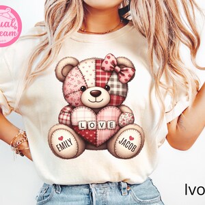 May include: Ivory t-shirt with a patchwork teddy bear design. The bear holds a heart with "LOVE" on it, and is surrounded by the names "Emily" and "Jacob." The Dual Dream Studio logo is in the upper left corner. The word "Ivory" is at the bottom.