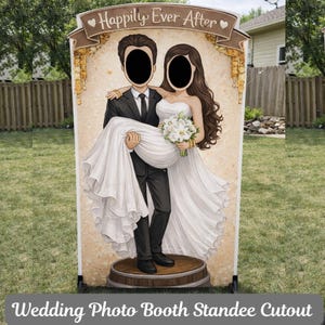 May include: A wedding photo booth standee cutout featuring a couple with face cutouts. The groom is holding the bride, who is wearing a white wedding dress and holding a bouquet. The top banner reads "Happily Ever After". The base of the standee is a wooden barrel.