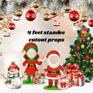 May include: Christmas-themed standee cutout props featuring a snowman, elf, and Santa Claus, each with a face cutout. The props are approximately 4 feet tall and include a Christmas tree, gifts, and candy canes. Festive decorations adorn the top.