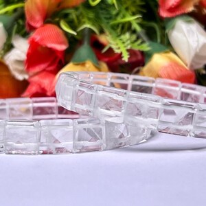 May include: Two clear crystal bracelets made of square-shaped beads. The bracelets are stacked on top of each other.