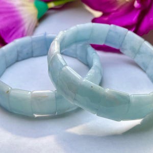 Op de afbeelding: Twee lichtblauwe aquamarijn stenen armbanden met vierkante kralen.