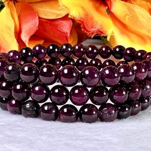 May include: A stack of three purple gemstone bracelets with round beads. The bracelets are made of natural stones and are perfect for layering.
