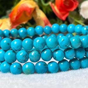 Könnte beinhalten: Ein türkisfarbenes Perlenarmband mit mehreren Reihen runder Perlen.