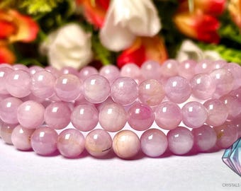 May include: A pink gemstone bracelet with round beads. The bracelet is made of multiple strands of beads, creating a layered effect.