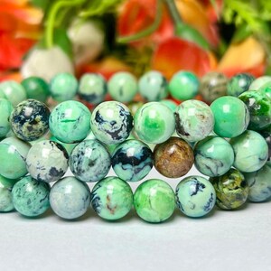 May include: A triple-strand bracelet made of green, white, and black marbled gemstone beads.