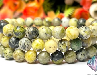 May include: A bracelet made of green and yellow jasper beads. The beads are round and have a speckled pattern.