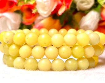 May include: A triple strand bracelet made of light yellow jade beads.