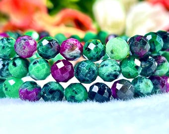 May include: A close-up of a multi-strand bracelet made of faceted green and purple gemstone beads. The beads are round and have a polished finish.