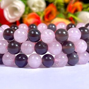 May include: A bracelet made of alternating pink and purple beads. The beads are round and smooth, and the bracelet is made of natural stone.