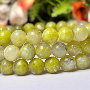 Op de afbeelding: Een armband gemaakt van groene en witte jade kralen. De kralen zijn rond en hebben een gladde, gepolijste afwerking.