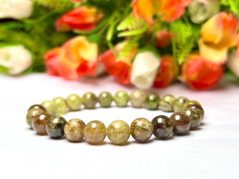 May include: A green and brown gemstone bracelet with round beads. The bracelet is made of natural stones and is a beautiful piece of jewelry.