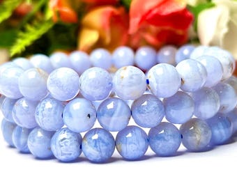 May include: A stack of three blue agate beaded bracelets. The beads are round and have a light blue color with white and brown patterns.