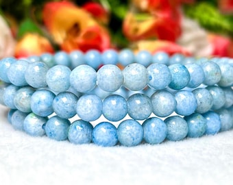 May include: A stack of light blue aquamarine gemstone bracelets. The beads are round and have a slightly textured surface.