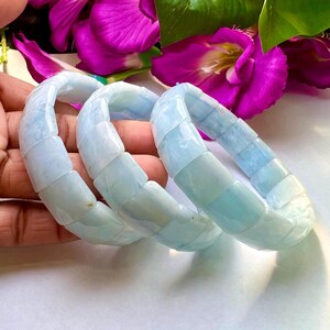 Op de afbeelding: Drie lichtblauwe aquamarijn stenen armbanden met vierkante kralen.