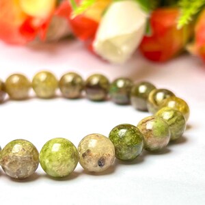 May include: A green and white gemstone bracelet with round beads. The beads have a mottled, marbled appearance.