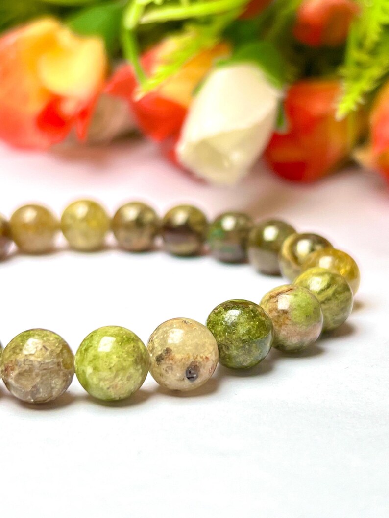 May include: A green and white gemstone bracelet with round beads. The beads have a mottled, marbled appearance.