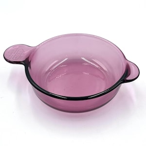 May include: A white ceramic mug with a black handle and the text "But First, Coffee" in a black, bold font. The mug is on a white surface.