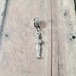 May include: Silver charm featuring a detailed mummy figure with a decorative scroll design at the top.