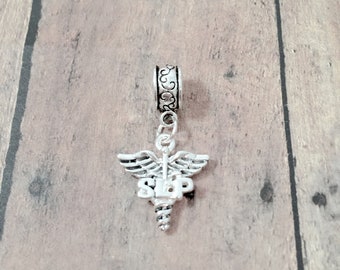 May include: Silver charm with a medical symbol and the word "SLAP" on it. The charm is attached to a silver chain.