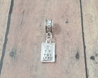 May include: Silver charm with an eye chart on a rectangular tag. The chart reads "E, FP, TOZ, LPED".