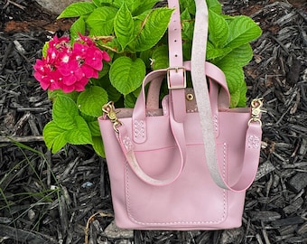 Mini bolso tote de edición limitada hecho a mano en piel rosa suave con correa cruzada ajustable y desmontable y bolsillo exterior.