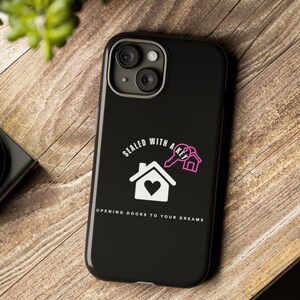 Può includere: Custodia per telefono nera con un design di casa e chiave bianca. Il testo recita "Sealed with a key, opening doors to your dreams".