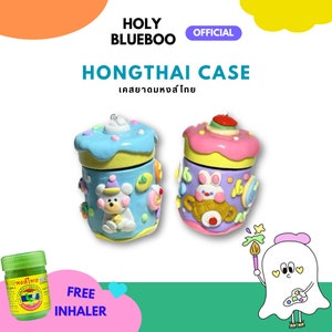 Puede incluir: Dos recipientes de cerámica con forma de pastel de colores con diseños de animales de dibujos animados. Los recipientes están decorados con colores pastel, chispas y caramelos. El texto "HONGTHAI CASE" y "เคสยาหอมสั่งไทย" se muestra encima de los recipientes. El texto "FREE INHALER" se muestra debajo de los recipientes.