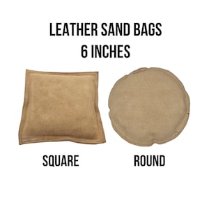 May include: Two tan leather sandbags, one square and one round, each approximately 6 inches in diameter. The text "LEATHER SAND BAGS 6 INCHES" is displayed above the bags, with the words "SQUARE" and "ROUND" below them.