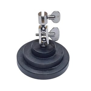 May include: A silver and black metal soldering station with a three-tiered base and adjustable arms.