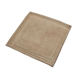 May include: A beige suede coaster with a stitched border.