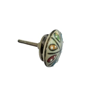 May include: A decorative ceramic cabinet knob with a colorful floral design. The knob features a cream-colored base with a pattern of colorful petals in red, orange, green, and blue. The hardware is silver-toned.